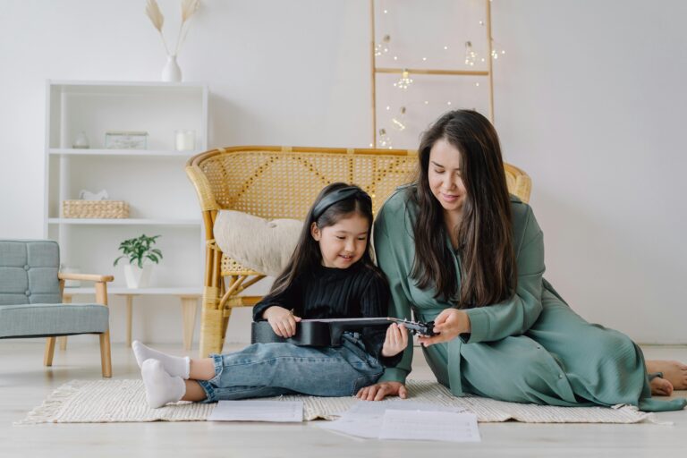 A mother and daughter enjoying a ukulele lesson together in a cozy living room environment.